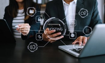 Hosting Schriftzug und Icons unterlegt mit Bild von zwei Personen an Laptop